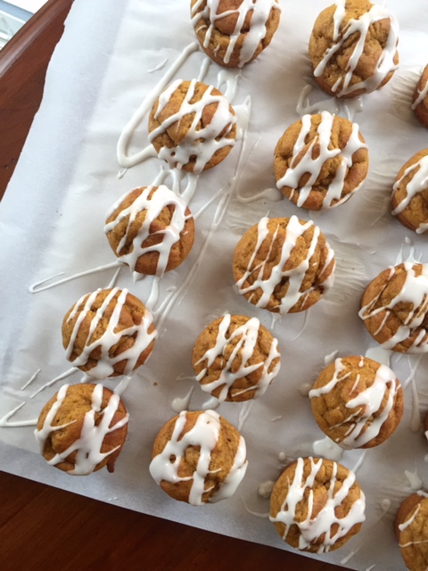 mini pumpkin muffins glazed on a sheet pan
