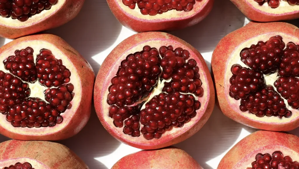 pomegranates cut so you can see the inside, and there are 3 of them side by side 