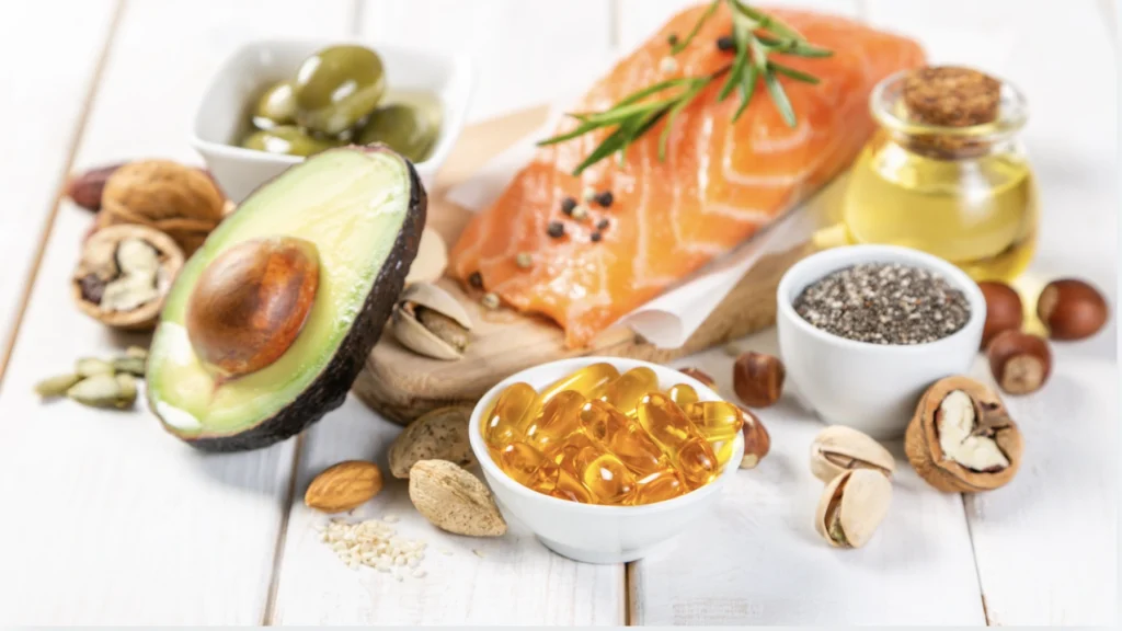 foods rich in fats, with salmon, avocado and fish oil supplements in the photo