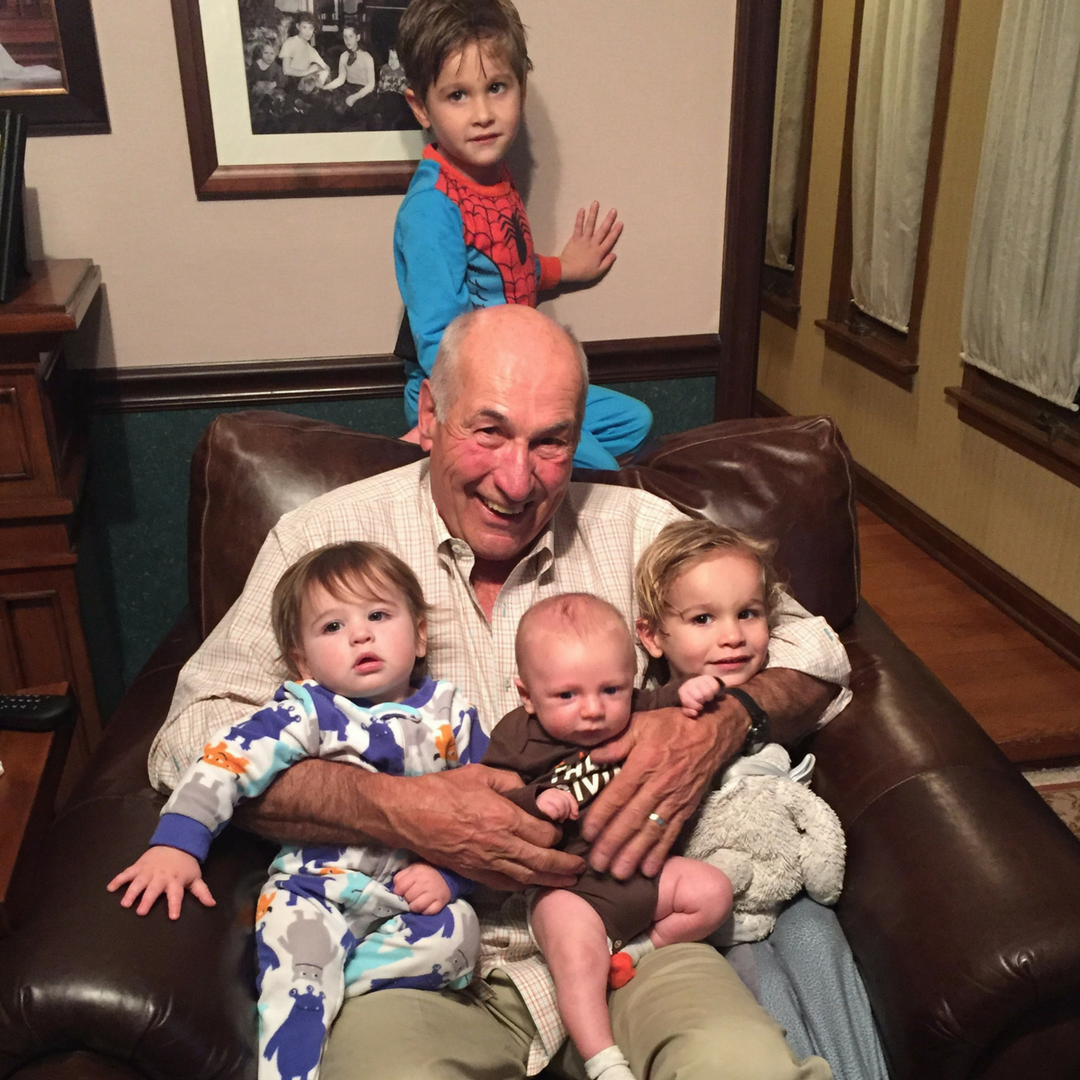 grandpa with four of his grandchildren sitting on his lap 
