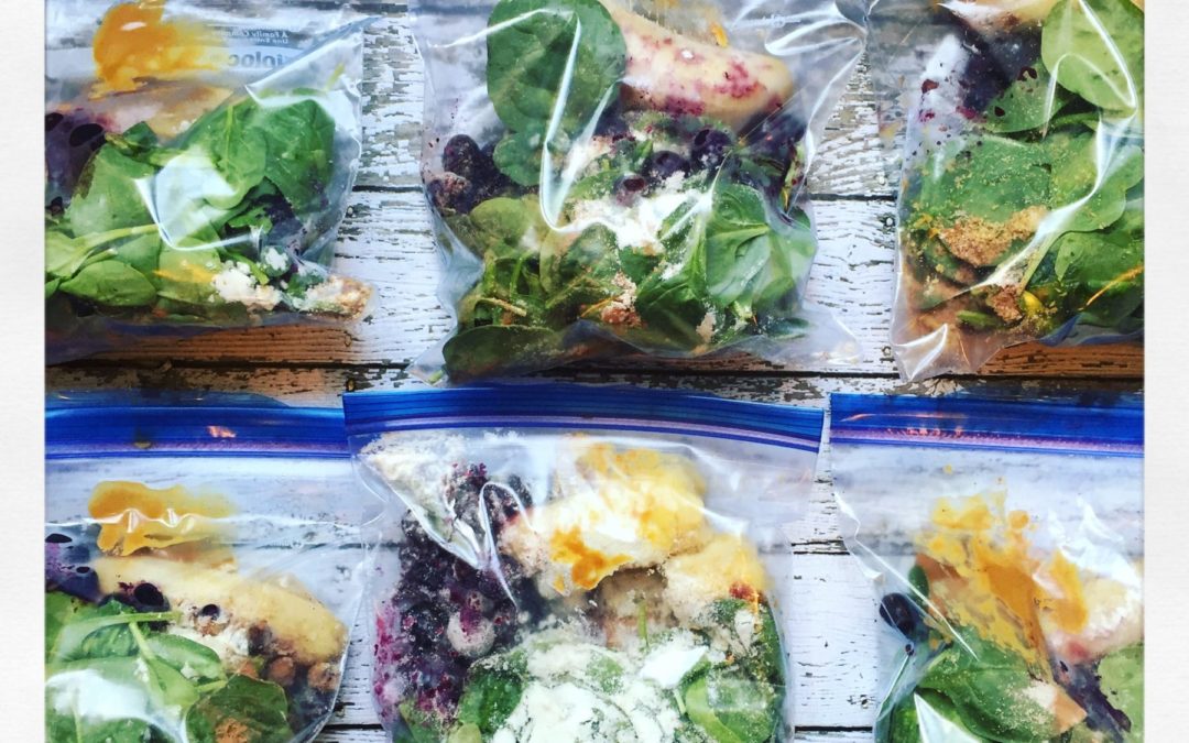 plastic bags filled with spinach, blueberries and peanut butter ready to make smoothies