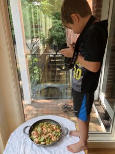 boy taking a picture of his stir fry recipe