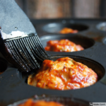 brush basting meatloaf in muffin tin