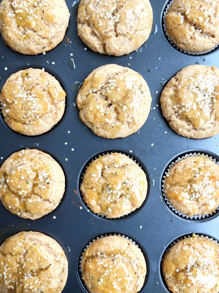 lemon muffins in the muffin tin, with hempseed sprinkles