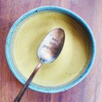 creamy citrus pistachio dressing in a small bowl with a spoon dipped into the dressing