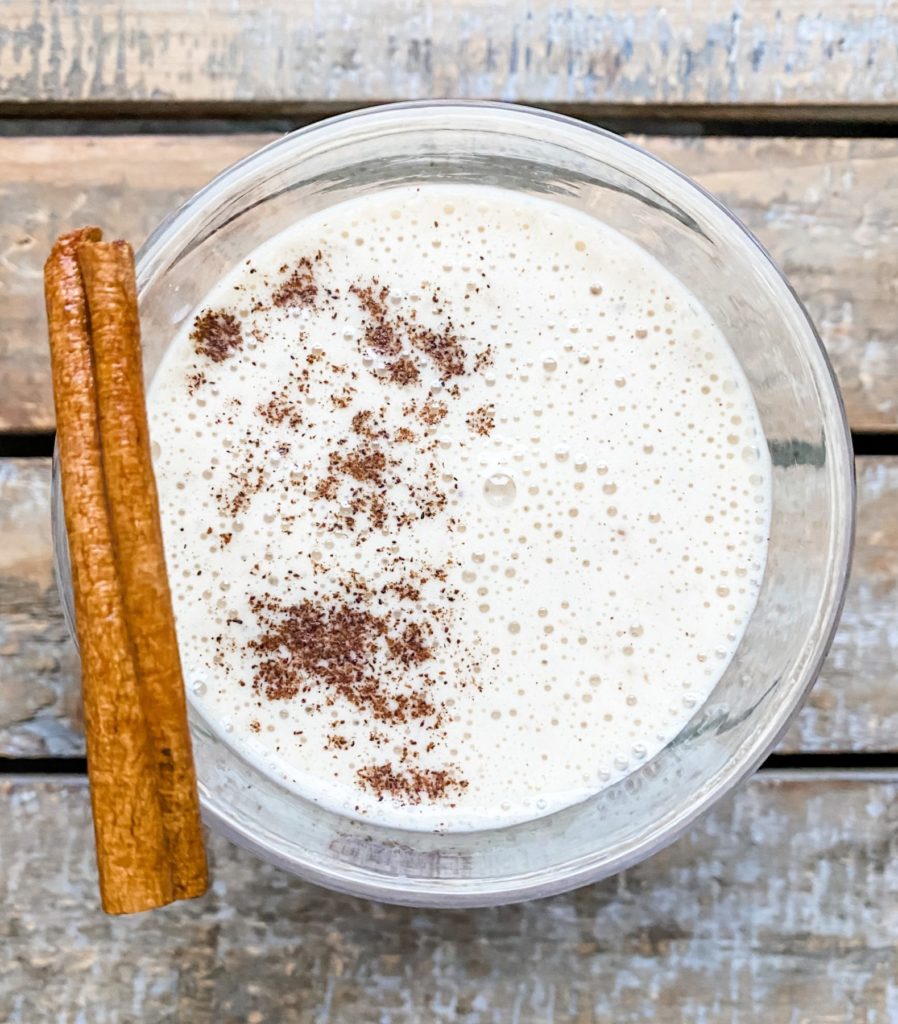 overhead view of eggnog smoothie with cinnamon stick