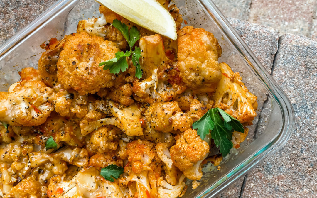 harissa cauliflower in a glass container with a lemon slice