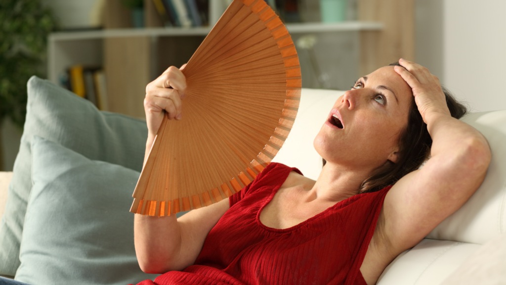 woman fanning herself in a menopause hot flash 