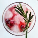 overhead shot of cranberry mocktail drink with rosemary