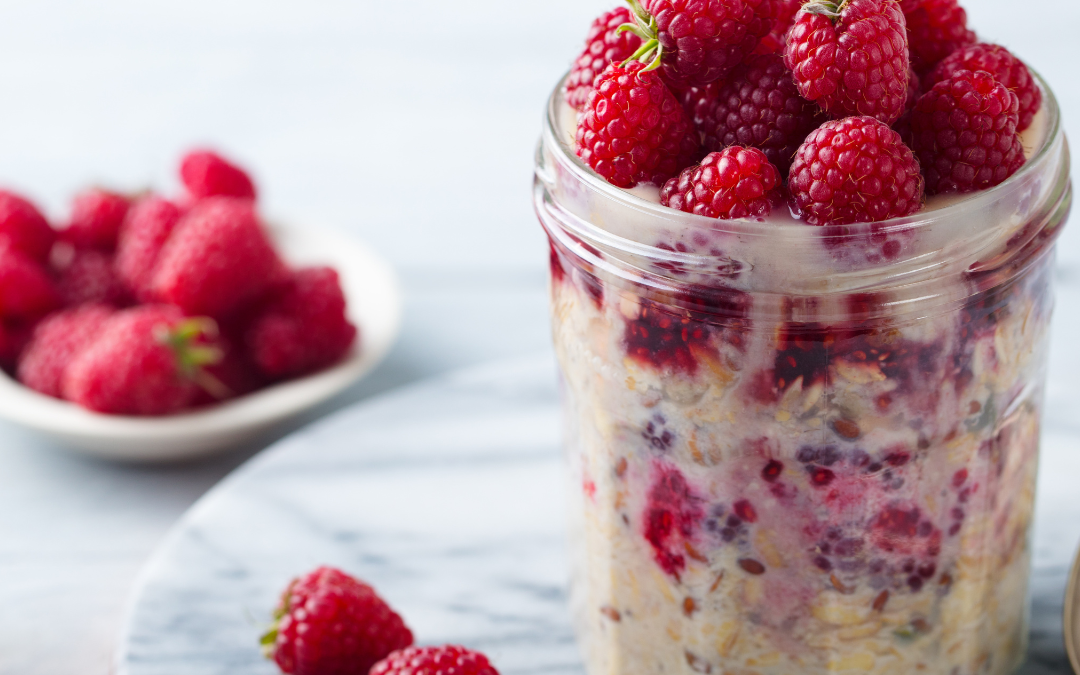 clear jar of kefir overnight oats with raspberries on top