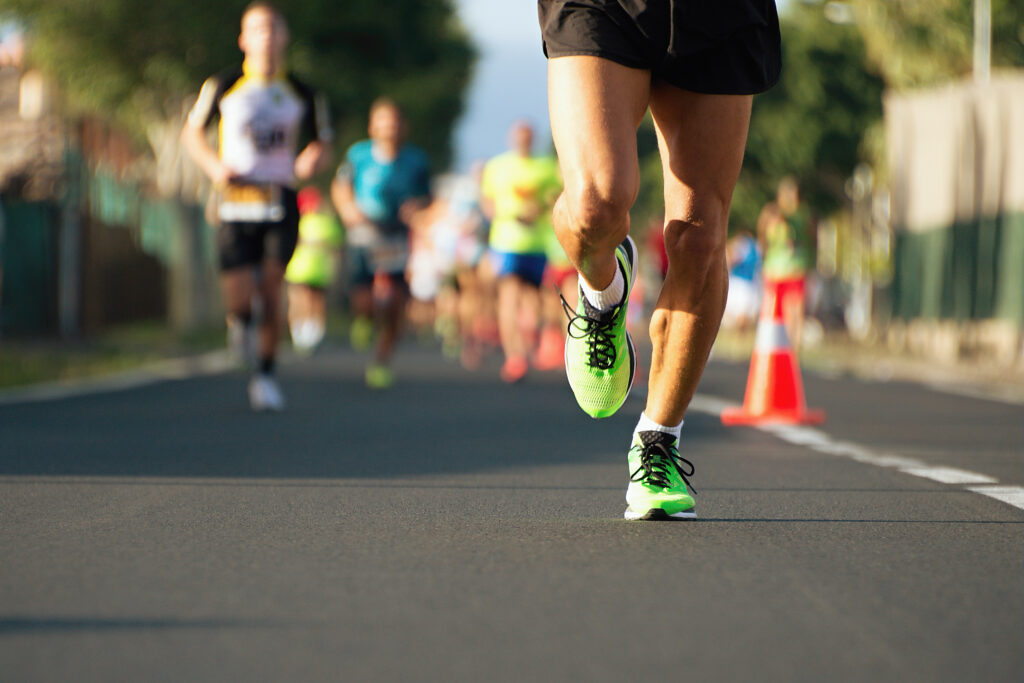 picture of a man's legs running in a road race working on his race day fueling