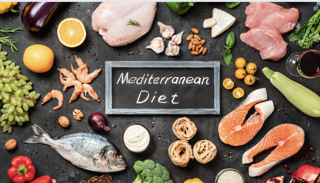 mediterranean foods on a black background such as chicken, salmon, pasta, fish, shrimp, grapes and lemons
