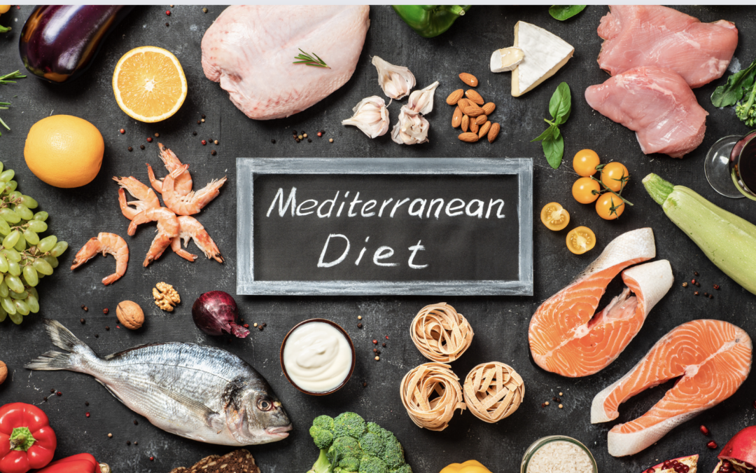 Mediterranean diet foods around a chalkboard, such as chicken, fish, and fruits and vegetables