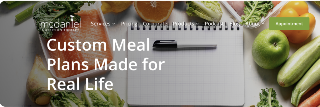 custom meal plans website photo with a pen, notebook and vegetables around the notebook