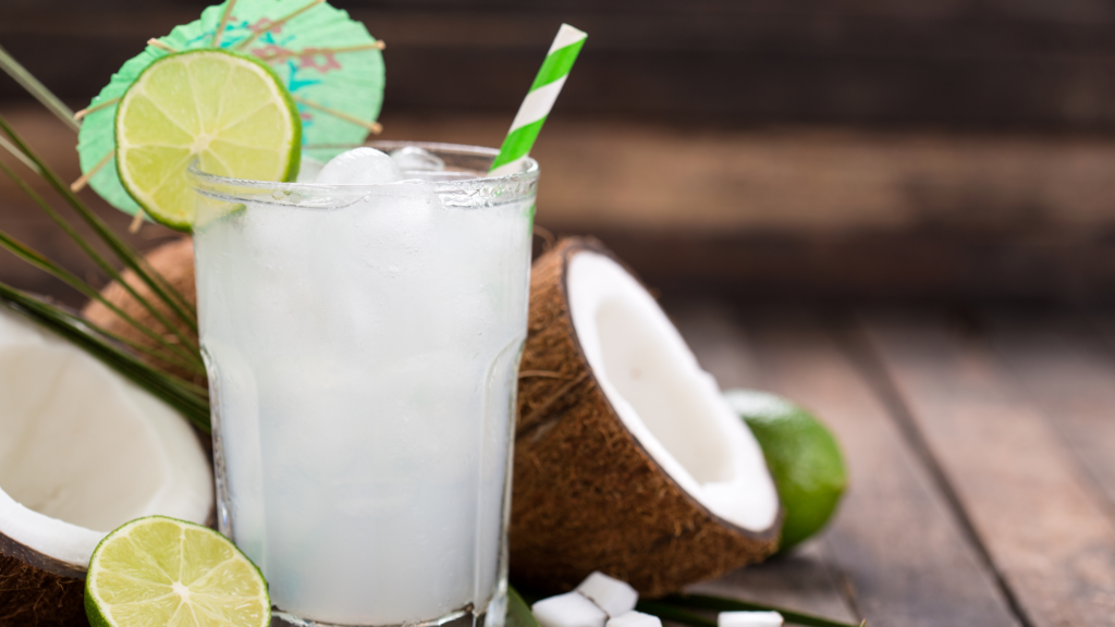 glass of coconut water with a lime and a straw