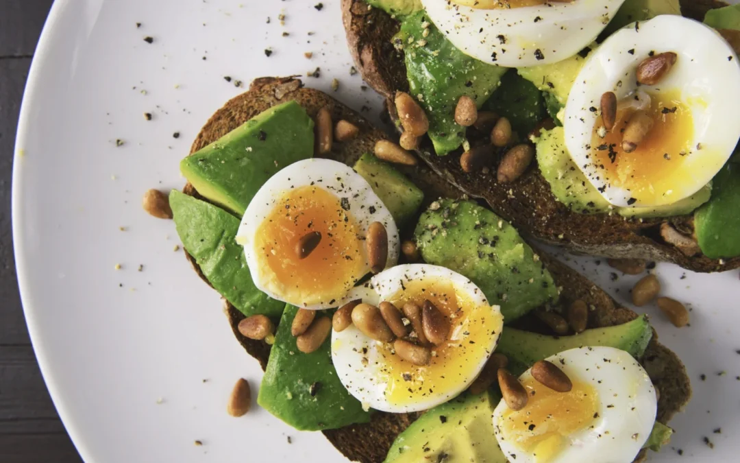 hard boiled eggs on toast with avocado and pine nuts