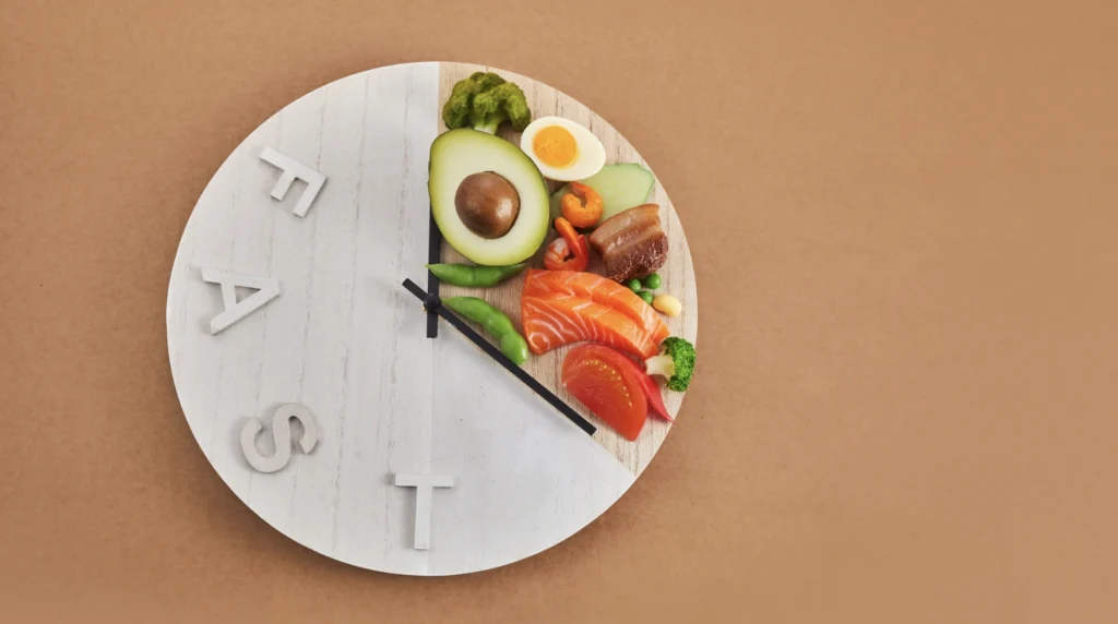 clock that says "FAST" and food in a small section to demonstrate intermittent fasting
